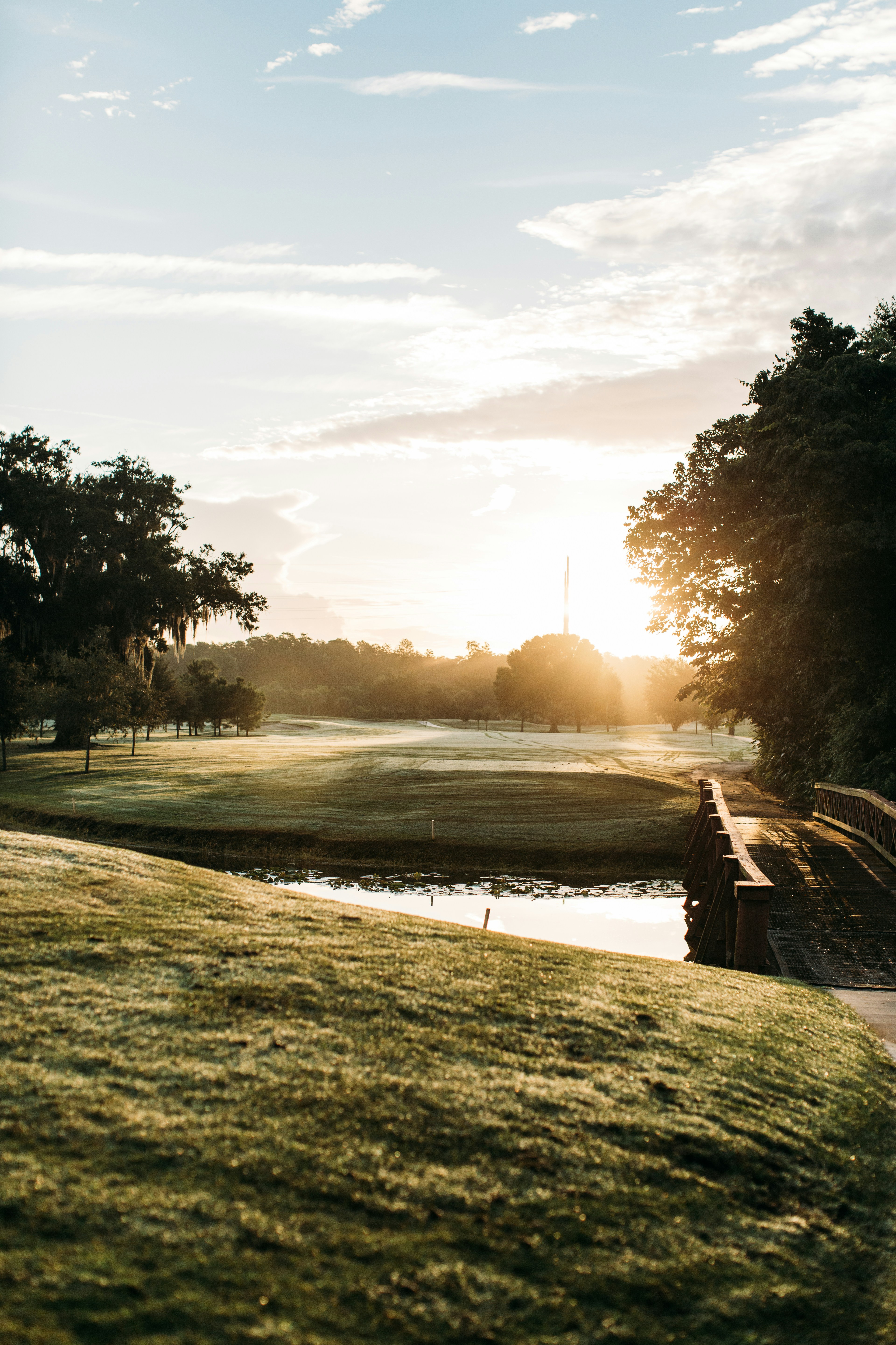 Golf course fairway at sunset with a pond and lush green grass in Central Florida
